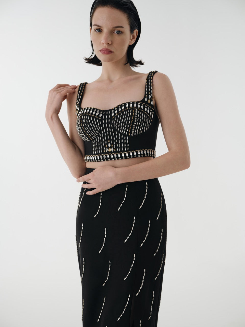 Woman wearing a black dress with white patterns on a white background